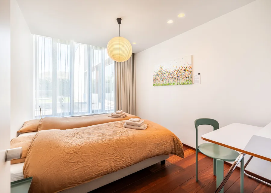 Slaapkamer met cognac beddengoed en Akari paperlamp